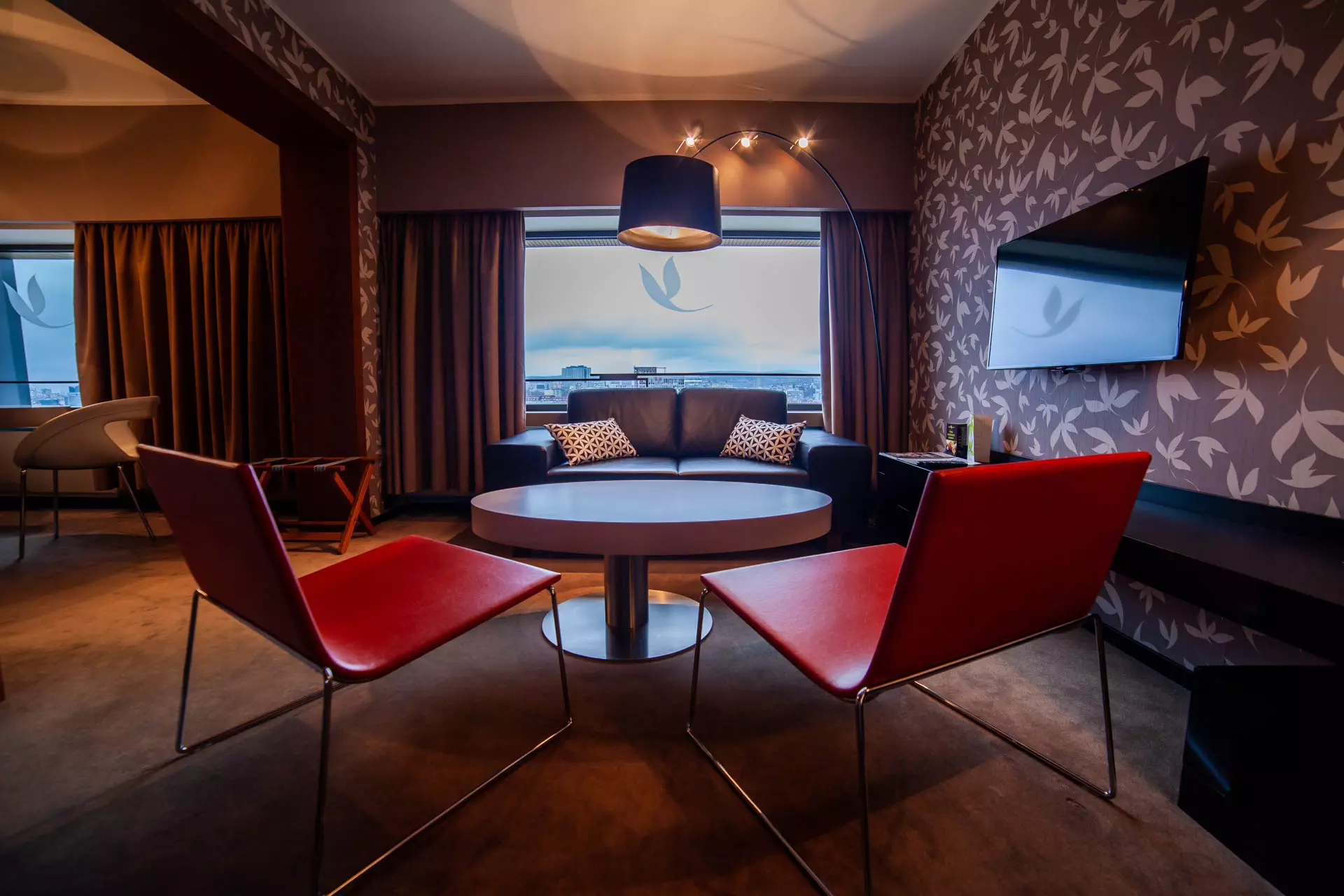 Fotografie priestorov obývačy hotela so stoličkami a výhľadom